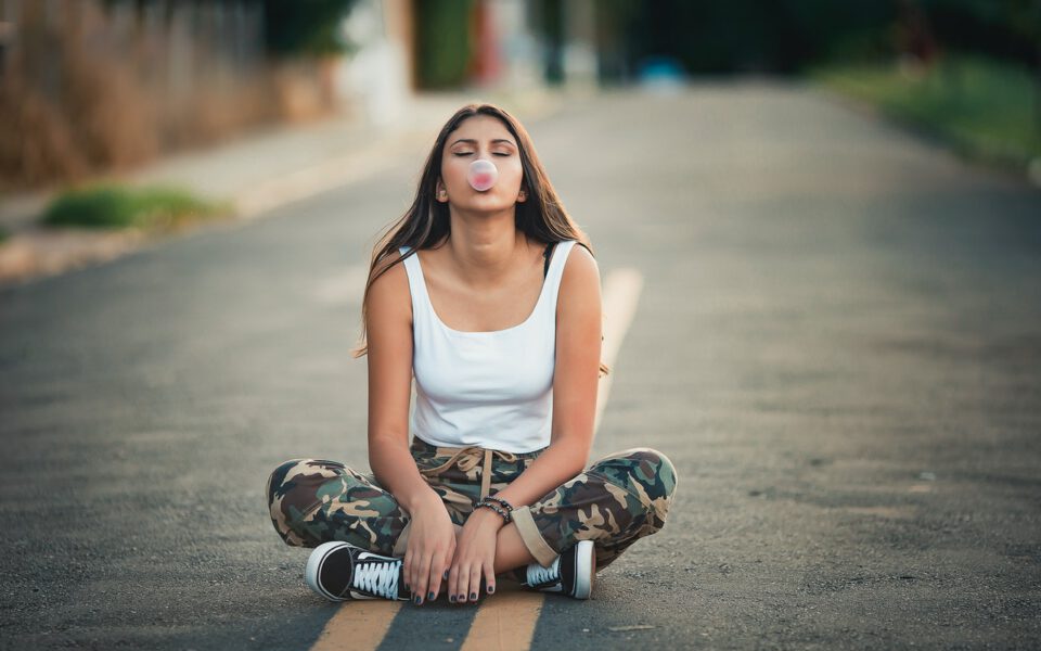 Girl is chewing gum sitting on the street